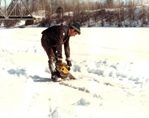 Mr. Ral Levasseur with a Chain Saw Cutting a Hole in the Ice