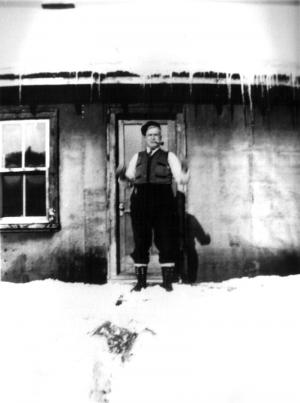 A Man Smoking his Pipe in Front of a Camp