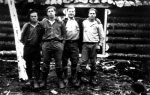Quatre travailleurs forestiers devant un camp
