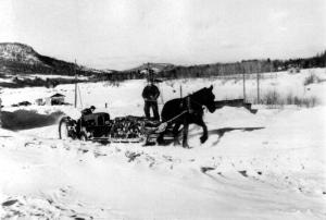 A Tractor Helping Move a Horse-Led Sled