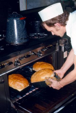 A Cook Taking Bread out of  the Oven