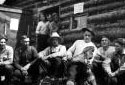 Man Playing Fiddle in Front of a Camp