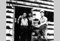 Trois travailleurs dans un camp en bois rond