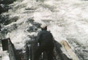 Driver on Logs Tied Together Going Downstream.
